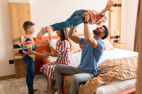Family of four having fun and enjoying together at hotel room.
